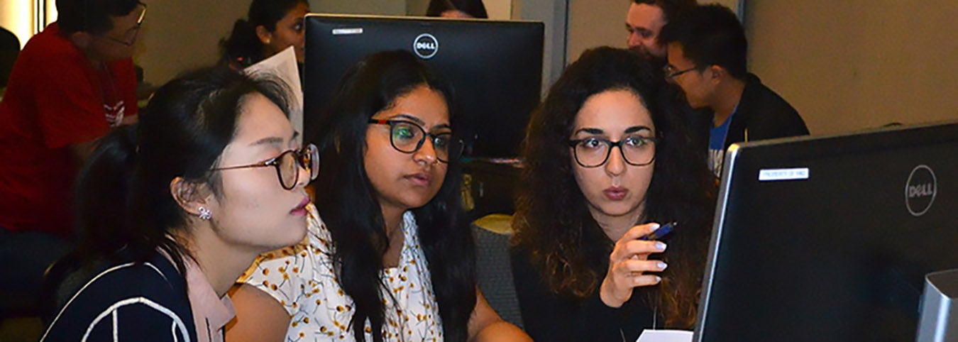 Photo of three women looking at computer screen